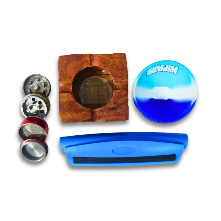 silicone rolling bowl with wooden ashtray, blue cigarette roller and metal herb grinder on a white background.