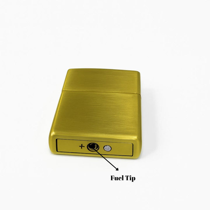 Gold lighter with fuel tip labeled on a white background