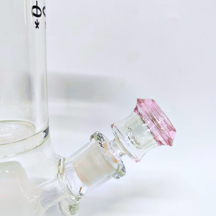 Close-up of a glass bottle bong with a pink glass bong shooter on a white background