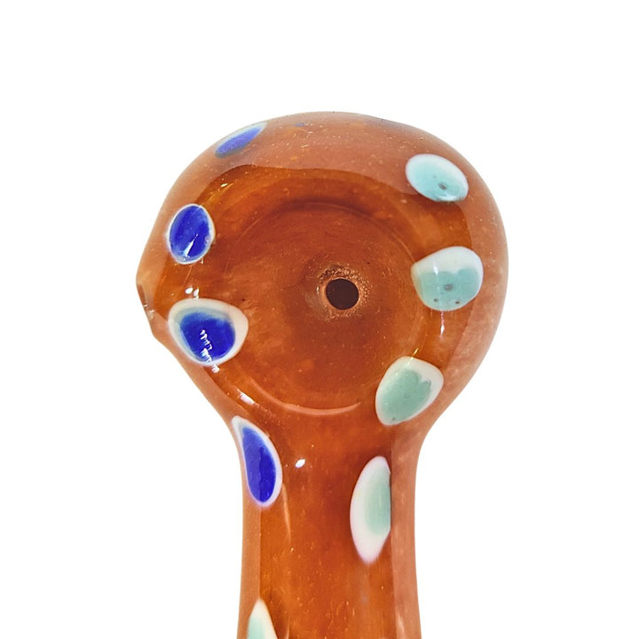 Glass pipe with brown body and colorful polka dot patterns on a white background