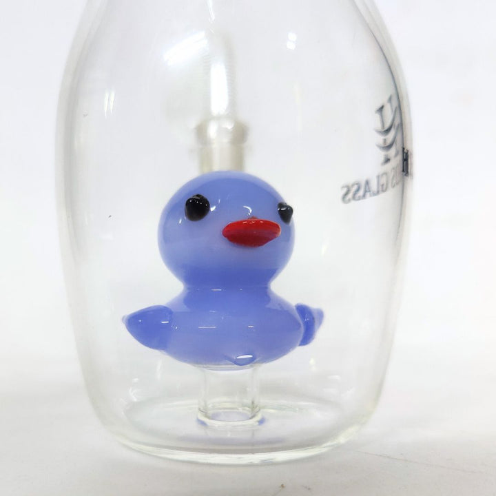 Small blue rubber duck inside a clear glass dome on a white background