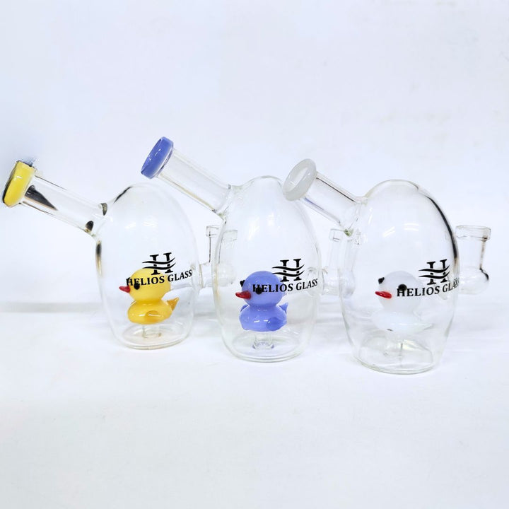 Glass smoking accessories with 'Helios Glass' branding and colorful duck decorations on a white background.