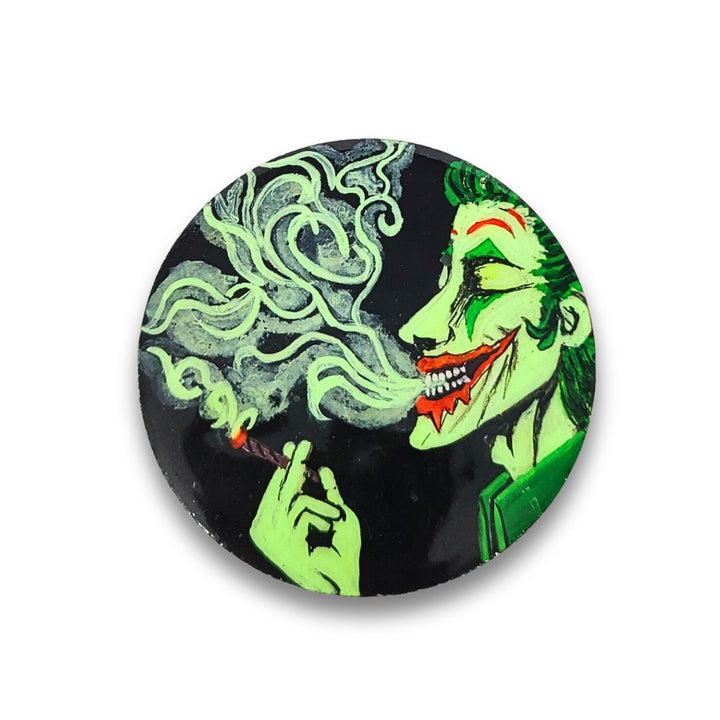 Herb Grinder with a green and black design of a character smoking a cigarette on a white background.
