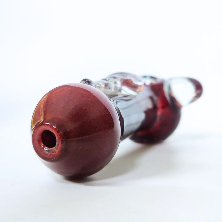 Glass smoking accessory with red-brown base on a white background
