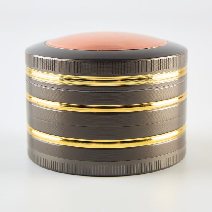 Round metallic grinder with gold and black accents on a white background