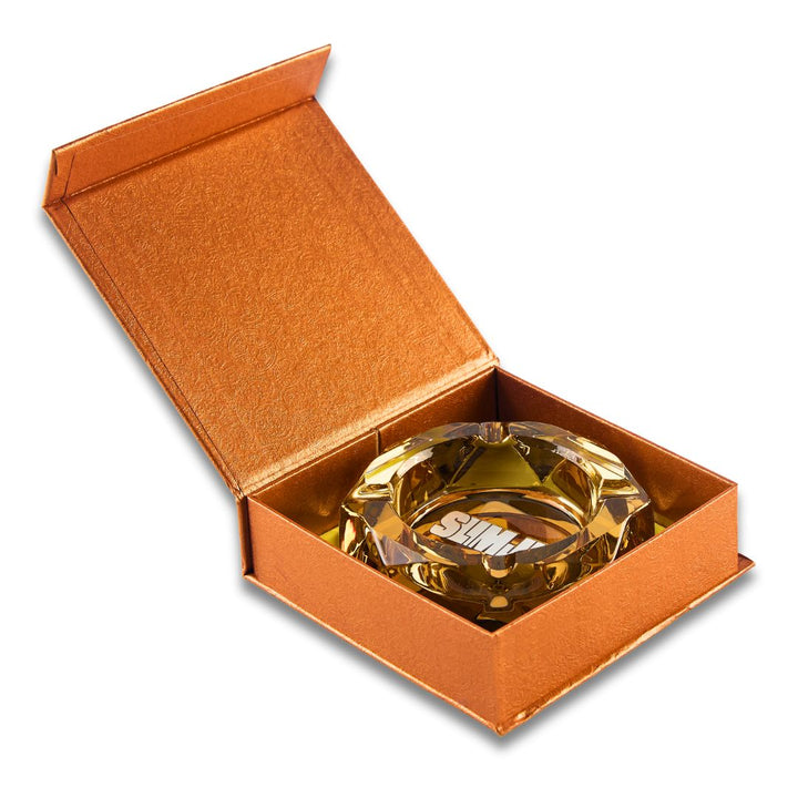 Gold ashtray with Slimjim text in a matching box on a white background