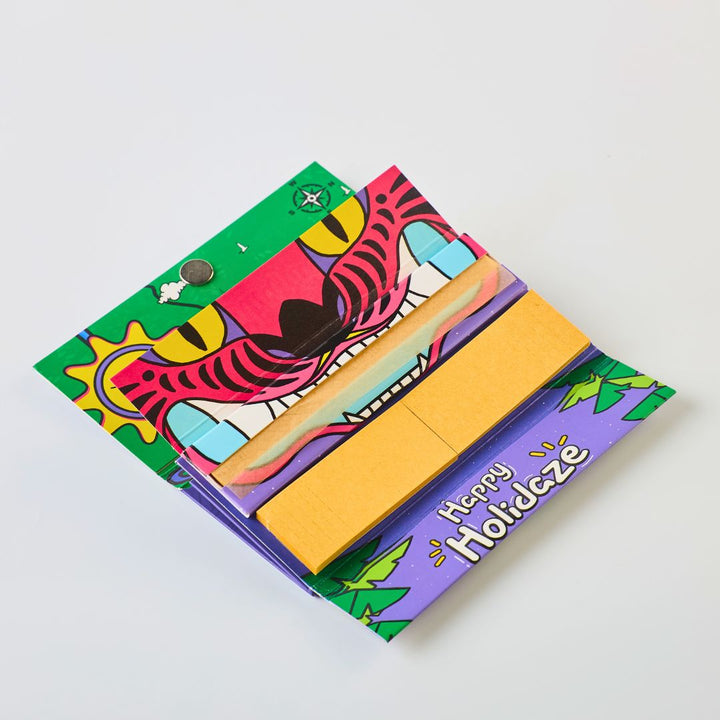 Colorful rolling paper set with a tiger design and 'Happy Holidaze' text on a white background