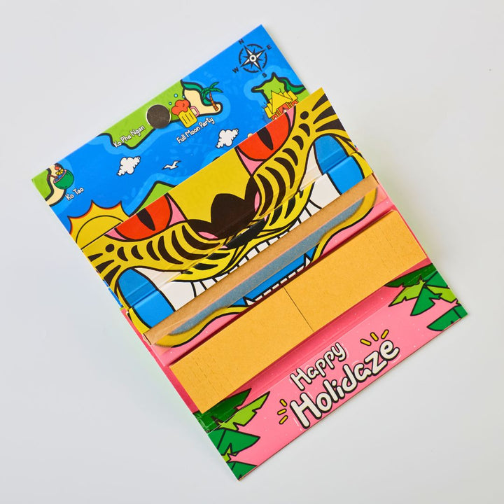 Colorful Rolling Paper pack with a tiger design and 'Happy Holidaze' text on a light gray background