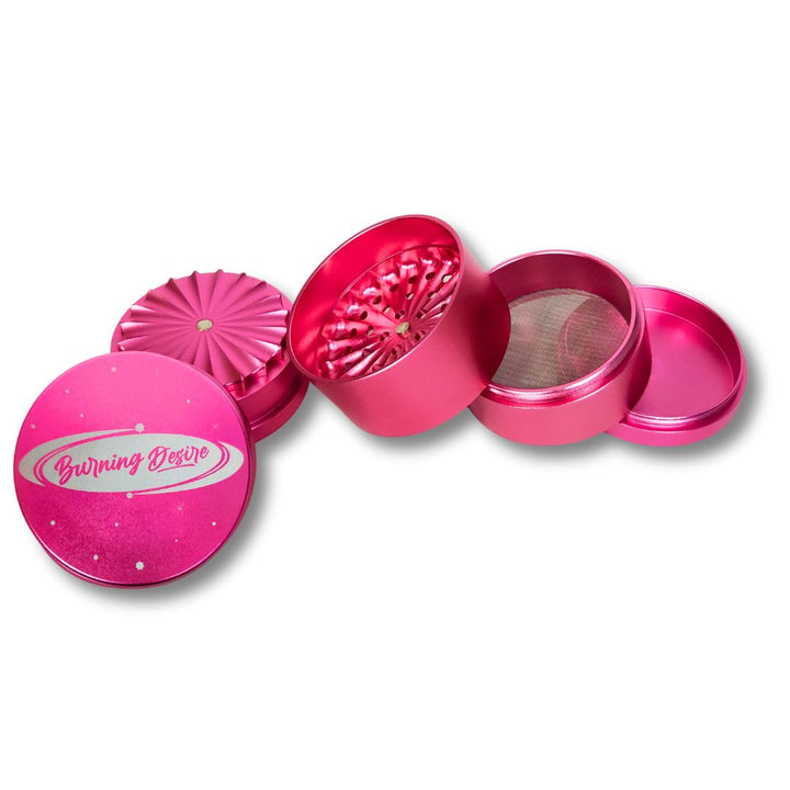 Pink herb grinder with 'Burning Desire' branding on a white background