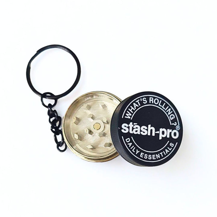 Keychain with a small metallic grinder and 'stash-pro' branding on a white background