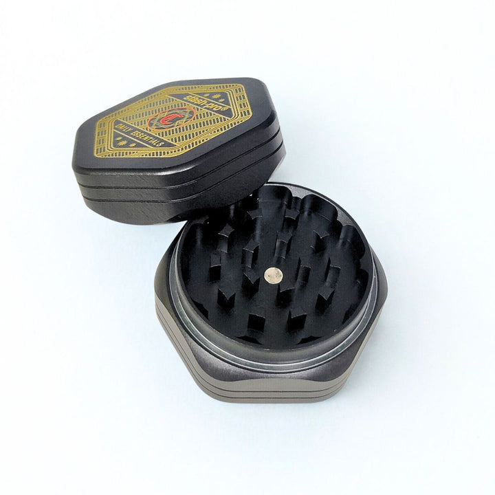 Black and silver herb grinder with open lid on a white background