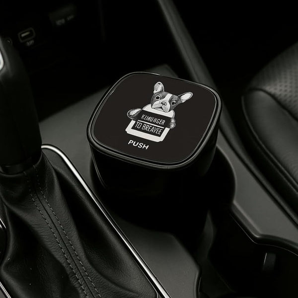 Black car ashtray  with a dog illustration and text in a vehicle interior.