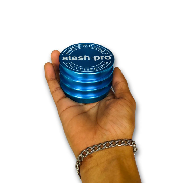 Blue 'stash-pro' rolling container held in a hand on a white background