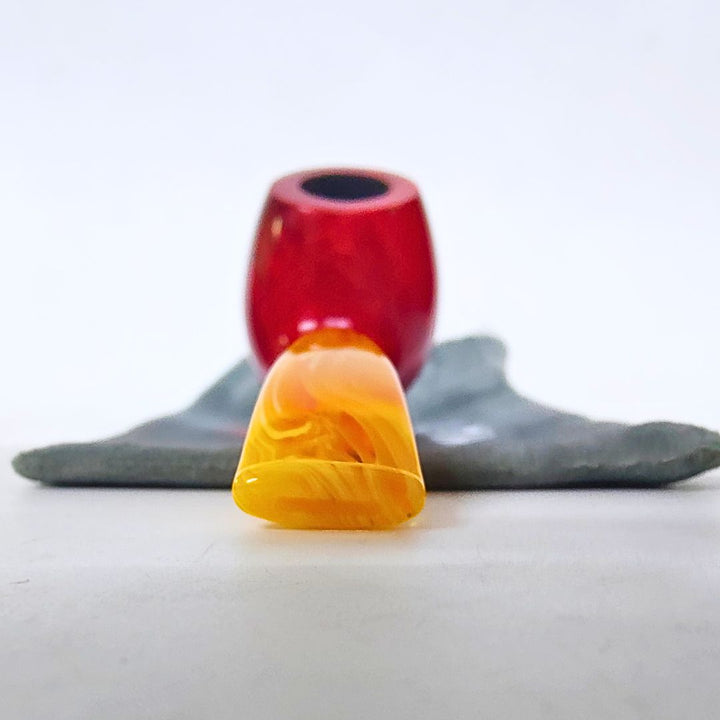 smoking pipe  with a red and black object in the background