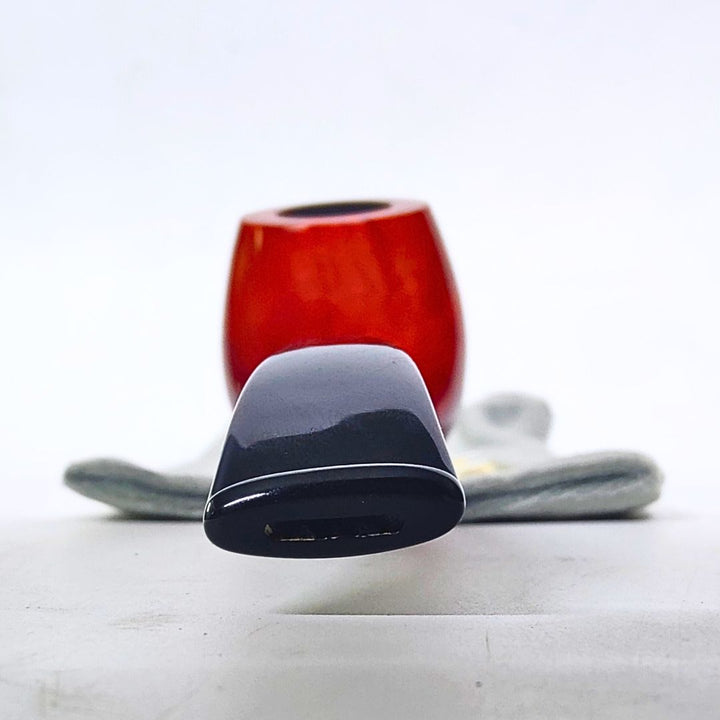 Close-up of a red and black smoking pipe on a white background